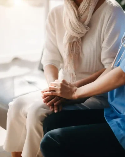 close-up-view-of-old-woman-leaning-on-nurse-while-2023-12-13-00-41-48-utc